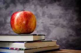 Apple in classroom on a pile of books